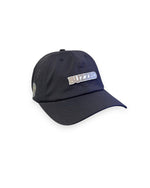 V's Barbershop black dad hat with perforated side panels and a BUZZED logo patch on the front.