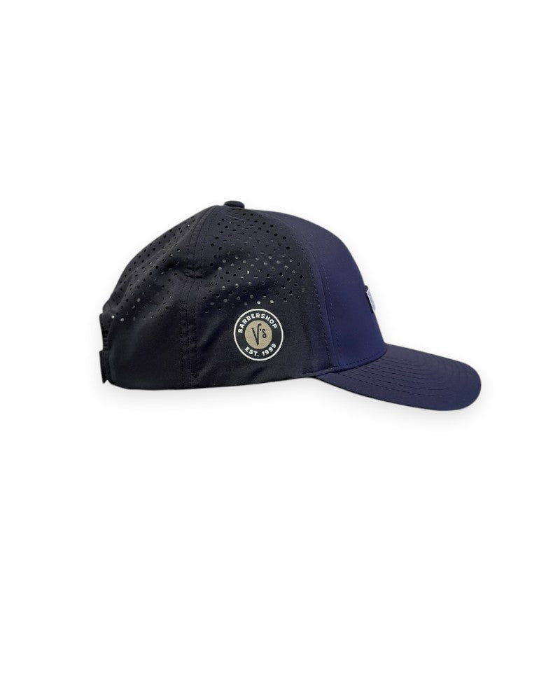 V's Barbershop black performance curved brim hat with laser-cut ventilation holes and side logo patch